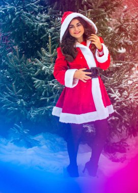 Genç Arap kadın kış günü, güzel bir Noel Baba ceketiyle karlı bir bahçede.