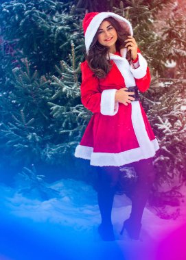 Genç Arap kadın kış günü, güzel bir Noel Baba ceketiyle karlı bir bahçede.