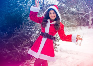 Genç Arap kadın kış günü, güzel bir Noel Baba ceketiyle karlı bir bahçede.