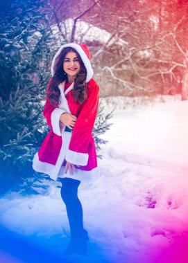 Genç Arap kadın kış günü, güzel bir Noel Baba ceketiyle karlı bir bahçede.