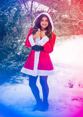 Genç Arap kadın kış günü, güzel bir Noel Baba ceketiyle karlı bir bahçede.