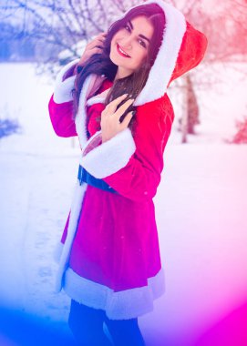 Genç Arap kadın kış günü, güzel bir Noel Baba ceketiyle karlı bir bahçede.