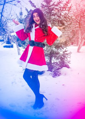 Genç Arap kadın kış günü, güzel bir Noel Baba ceketiyle karlı bir bahçede.