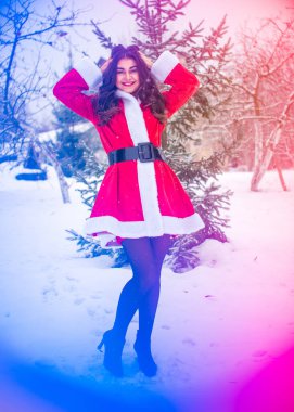 Genç Arap kadın kış günü, güzel bir Noel Baba ceketiyle karlı bir bahçede.