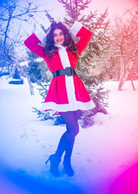 Genç Arap kadın kış günü, güzel bir Noel Baba ceketiyle karlı bir bahçede.