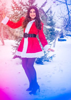 Genç Arap kadın kış günü, güzel bir Noel Baba ceketiyle karlı bir bahçede.