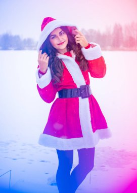 Genç Arap kadın kış günü, güzel bir Noel Baba ceketiyle karlı bir bahçede.