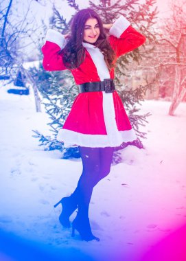 Genç Arap kadın kış günü, güzel bir Noel Baba ceketiyle karlı bir bahçede.