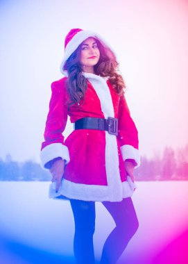 Genç Arap kadın kış günü, güzel bir Noel Baba ceketiyle karlı bir bahçede.