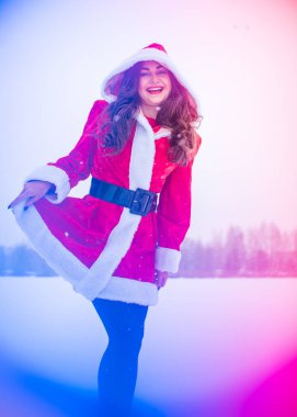 Genç Arap kadın kış günü, güzel bir Noel Baba ceketiyle karlı bir bahçede.