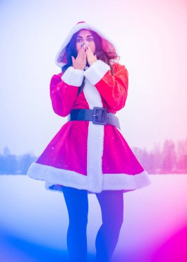 Genç Arap kadın kış günü, güzel bir Noel Baba ceketiyle karlı bir bahçede.