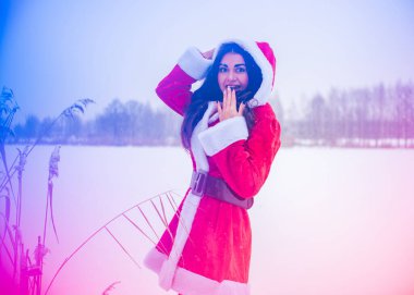 Genç Arap kadın kış günü, güzel bir Noel Baba ceketiyle karlı bir bahçede.