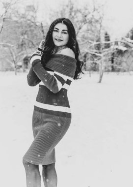 Karlı kış gününde siyah saçlı, örgü kırmızısı elbiseli İspanyol bir kadın. Sıradan moda anlayışı.