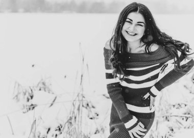 Karlı kış gününde siyah saçlı, örgü kırmızısı elbiseli İspanyol bir kadın. Sıradan moda anlayışı.