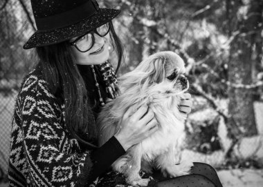 Küçük altın köpekli kadın mavi yün ceket ve örgü eşarp giyiyor, günlük tarz, kış karlı hava yürüyüşleri
