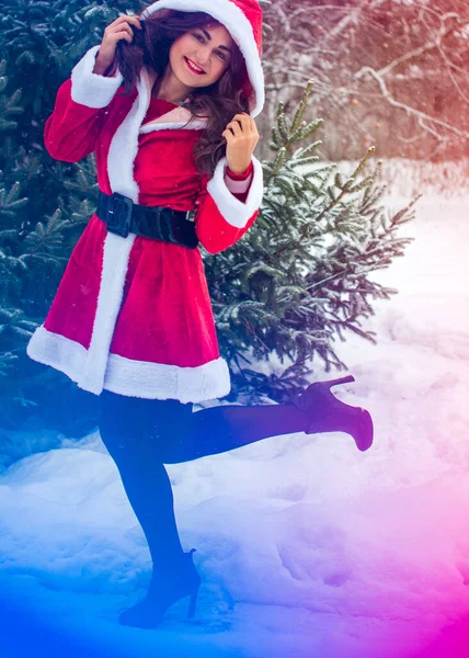 Genç Arap kadın kış günü, güzel bir Noel Baba ceketiyle karlı bir bahçede.