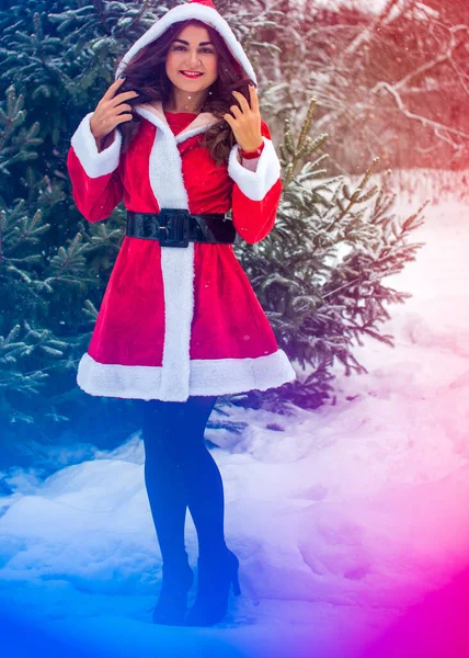 Genç Arap kadın kış günü, güzel bir Noel Baba ceketiyle karlı bir bahçede.