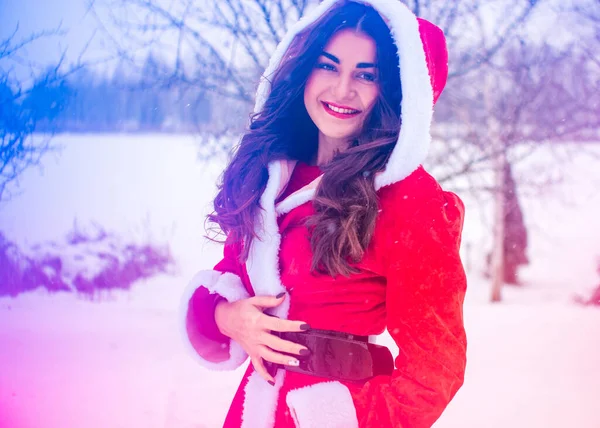 Genç Arap kadın kış günü, güzel bir Noel Baba ceketiyle karlı bir bahçede.