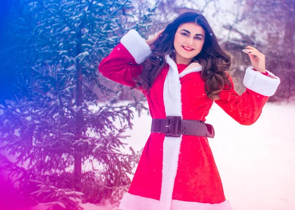 Genç Arap kadın kış günü, güzel bir Noel Baba ceketiyle karlı bir bahçede.