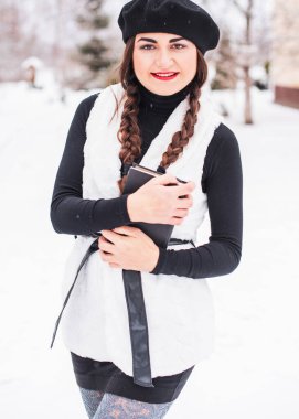 Sokakta poz veren güzel bir kadının açık hava portresi. Siyah bere takan ve örgü ören bir manken. Kadın moda konsepti