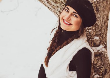 Sokakta poz veren güzel bir kadının açık hava portresi. Siyah bere takan ve örgü ören bir manken. Kadın moda konsepti