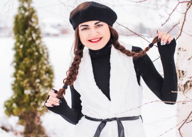 Sokakta poz veren güzel bir kadının açık hava portresi. Siyah bere takan ve örgü ören bir manken. Kadın moda konsepti