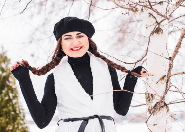 Sokakta poz veren güzel bir kadının açık hava portresi. Siyah bere takan ve örgü ören bir manken. Kadın moda konsepti