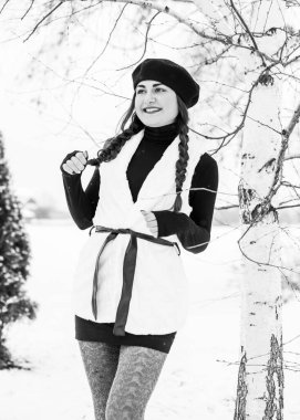 Sokakta poz veren güzel bir kadının açık hava portresi. Siyah bere takan ve örgü ören bir manken. Kadın moda konsepti