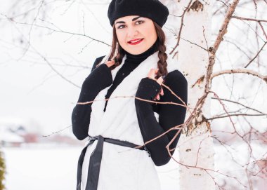 Sokakta poz veren güzel bir kadının açık hava portresi. Siyah bere takan ve örgü ören bir manken. Kadın moda konsepti