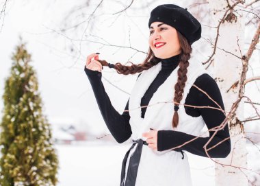 Sokakta poz veren güzel bir kadının açık hava portresi. Siyah bere takan ve örgü ören bir manken. Kadın moda konsepti