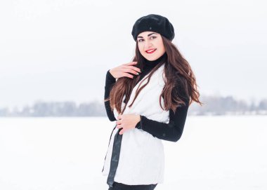 Sokakta poz veren güzel bir kadının açık hava portresi. Siyah bere takan ve örgü ören bir manken. Kadın moda konsepti