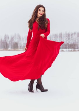 Karlı bir günde ipek elbiseyle dans eden İspanyol bir kadın, kırmızı elbisenin dalgalanması ve çırpınması, tutku konsepti