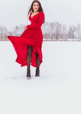 Karlı bir günde ipek elbiseyle dans eden İspanyol bir kadın, kırmızı elbisenin dalgalanması ve çırpınması, tutku konsepti