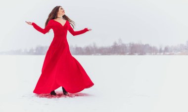 Karlı bir günde ipek elbiseyle dans eden İspanyol bir kadın, kırmızı elbisenin dalgalanması ve çırpınması, tutku konsepti