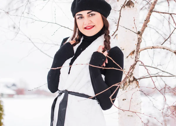 Sokakta poz veren güzel bir kadının açık hava portresi. Siyah bere takan ve örgü ören bir manken. Kadın moda konsepti