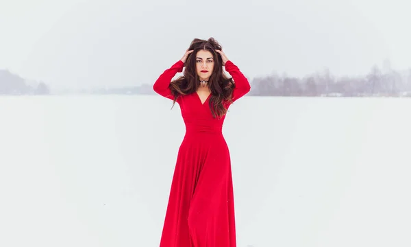 雪の日の絹のドレスで踊るヒスパニック系の女性 芸術的な赤い流れるガウンを振って 布をなびかせ 情熱の概念 — ストック写真