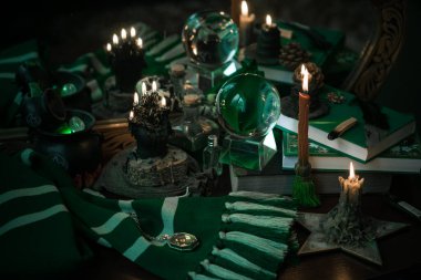 Büyü okulunun konuları mum ışığı eşarbı, sihirli şeyler, büyü kitabı karanlık arka plan, Slytherin estetiği.