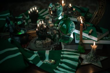 Büyü okulunun konuları mum ışığı eşarbı, sihirli şeyler, büyü kitabı karanlık arka plan, Slytherin estetiği.