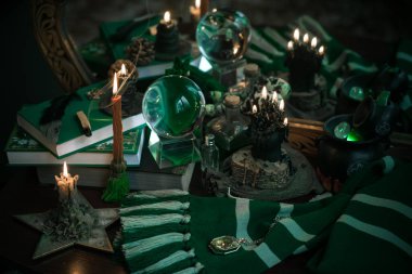 Büyü okulunun konuları mum ışığı eşarbı, sihirli şeyler, büyü kitabı karanlık arka plan, Slytherin estetiği.