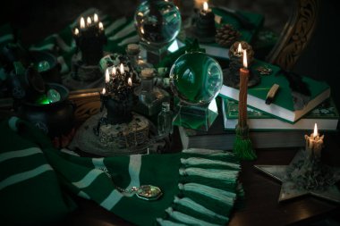Büyü okulunun konuları mum ışığı eşarbı, sihirli şeyler, büyü kitabı karanlık arka plan, Slytherin estetiği.