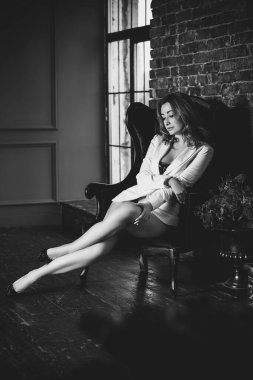 Klasik iç mekanda siyah vücutlu seksi kızıl kadın. Şık vücutlu, dolgun kalçalı, güzel bacaklı bir bayan.