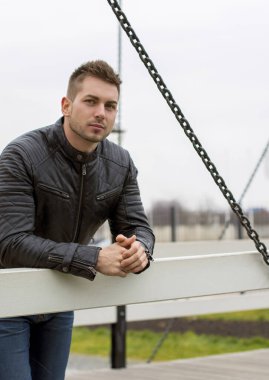 İlginç bir genç adam mavi kot pantolon, siyah ceket, şık saç, iyi ruh hali, telefon, güzel moda erkek arkadaş, vatandaş, yalnız, güzel yüzlü.