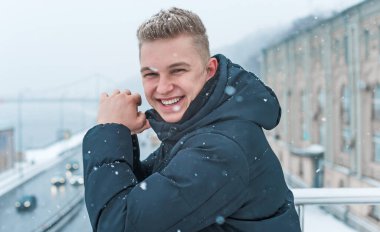 Smiling young handsome student, blonde guy, lifestyle of teen life. Portrait at winter