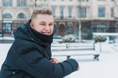 Smiling young handsome student, blonde guy, lifestyle of teen life. Portrait at winter