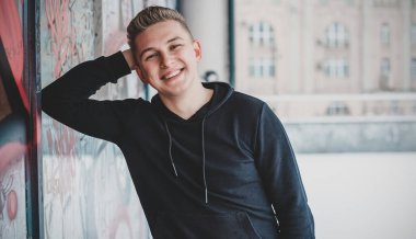 Smiling young handsome student, blonde guy, lifestyle of teen life. Portrait at winter