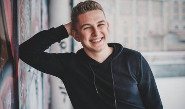Smiling young handsome student, blonde guy, lifestyle of teen life. Portrait at winter