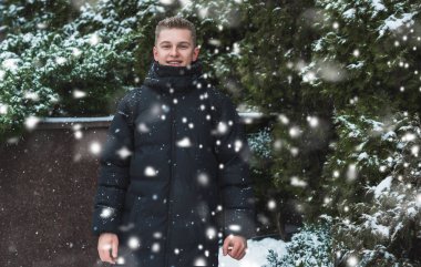 Smiling young handsome student, blonde guy, lifestyle of teen life. Portrait at winter