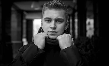 Portrait of young blonde guy Nordic appearance, lifestyle of young people. Handsome guy close up, winter day thinking about something