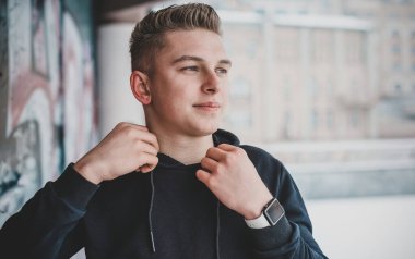 Portrait of young blonde guy Nordic appearance, lifestyle of young people. Handsome guy close up, winter day thinking about something