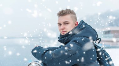 Portrait of young blonde guy Nordic appearance, lifestyle of young people. Handsome guy close up, winter day thinking about something